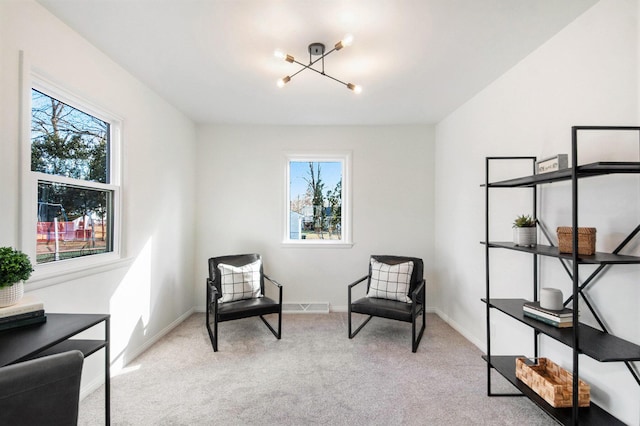 sitting room featuring a healthy amount of sunlight, a notable chandelier, light carpet, and baseboards