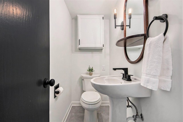 bathroom featuring toilet, tile patterned flooring, and baseboards