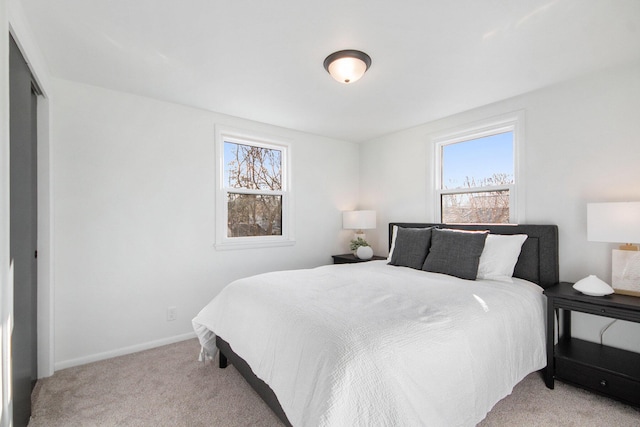 bedroom with baseboards and light colored carpet