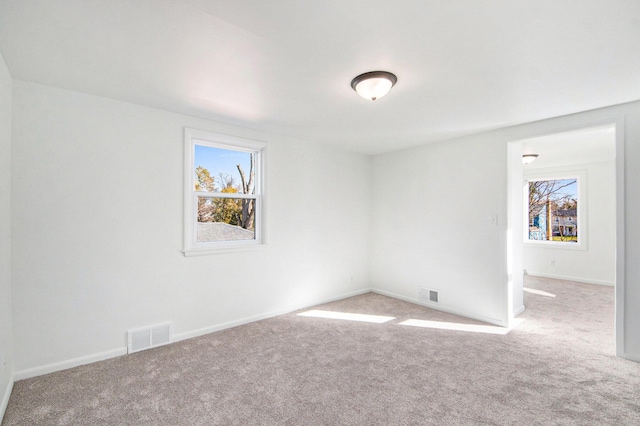 carpeted empty room with visible vents and baseboards