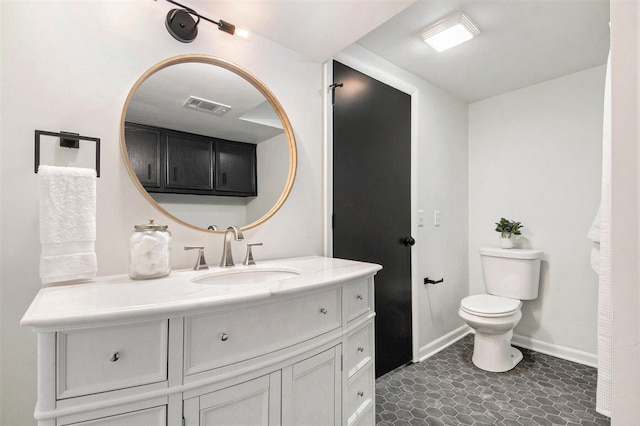 bathroom featuring toilet, vanity, visible vents, and baseboards