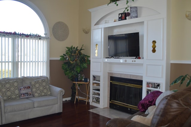 living area featuring built in features, a fireplace, and wood finished floors