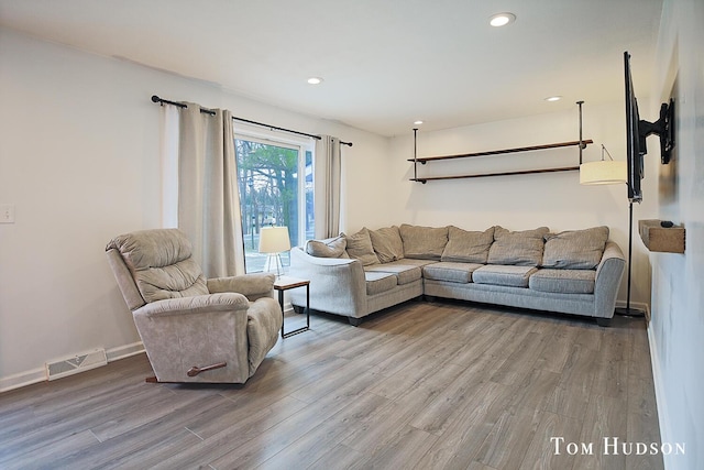 living room featuring baseboards, wood finished floors, visible vents, and recessed lighting