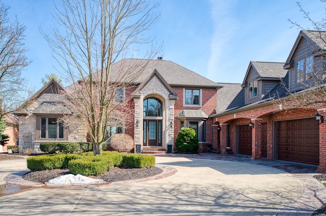 view of front of property with stone siding, brick siding, driveway, and a shingled roof