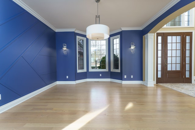 interior space featuring a healthy amount of sunlight, crown molding, baseboards, and wood finished floors