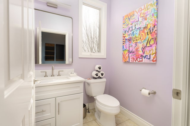 half bathroom with tile patterned floors, toilet, vanity, and baseboards