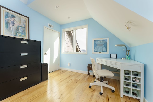 office featuring visible vents, lofted ceiling, light wood-style floors, and baseboards