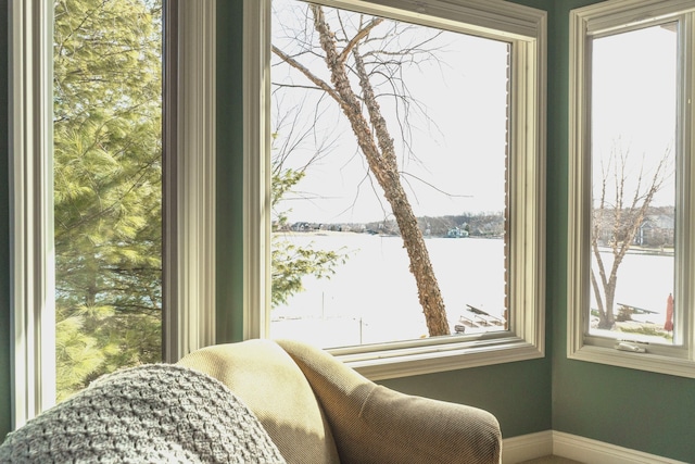 sitting room featuring baseboards and a water view