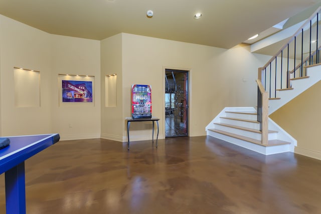 recreation room with recessed lighting, baseboards, and concrete flooring