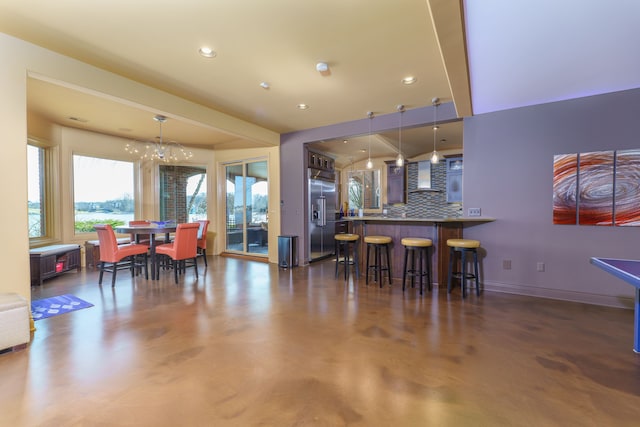 dining area featuring recessed lighting, finished concrete flooring, baseboards, and a chandelier