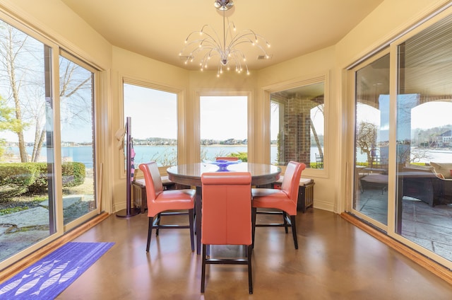 sunroom featuring a wealth of natural light, a water view, and an inviting chandelier