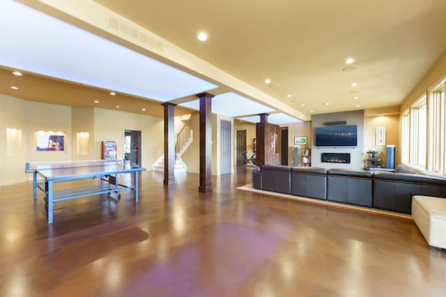 living area featuring recessed lighting, visible vents, finished concrete flooring, and stairs