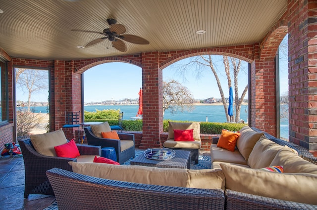 view of patio featuring an outdoor living space, a ceiling fan, and a water view