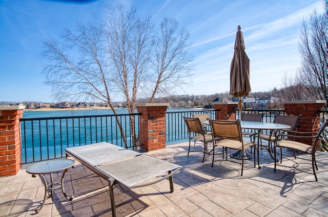 view of patio with outdoor dining area and a water view