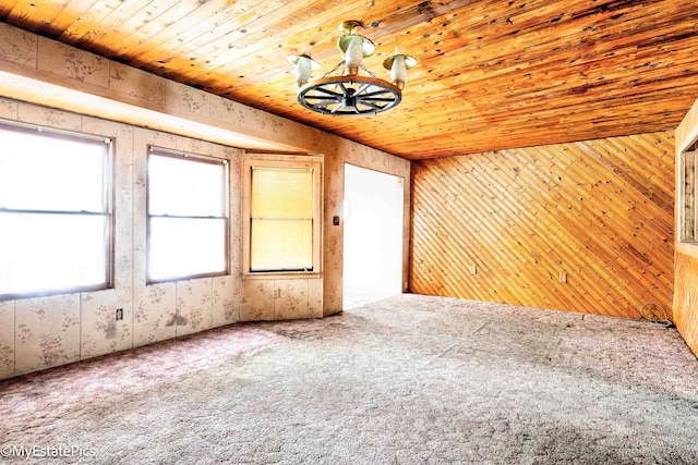 carpeted spare room with wood ceiling