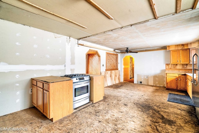 kitchen featuring stainless steel gas stove, open floor plan, visible vents, and a ceiling fan