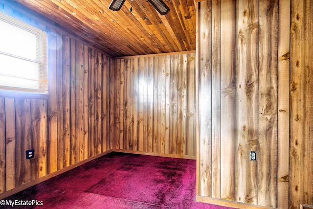 unfurnished room with wood ceiling, wooden walls, baseboards, and a ceiling fan