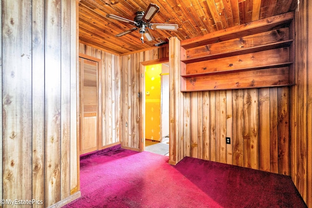 unfurnished room featuring wood ceiling, carpet flooring, wood walls, and ceiling fan