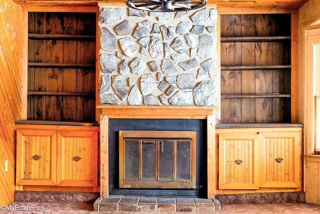 details featuring built in shelves and a glass covered fireplace