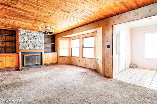 unfurnished living room with a chandelier, carpet floors, wooden ceiling, and a fireplace