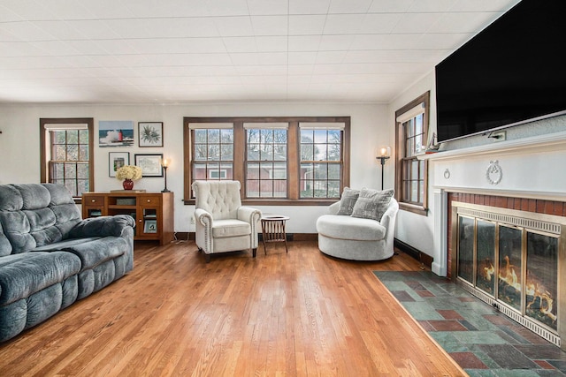 living room featuring a fireplace, wood finished floors, and baseboards