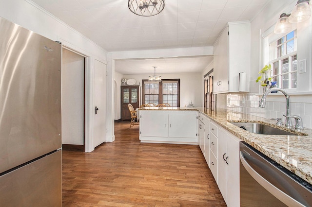 kitchen featuring light wood-type flooring, tasteful backsplash, stainless steel appliances, and a sink