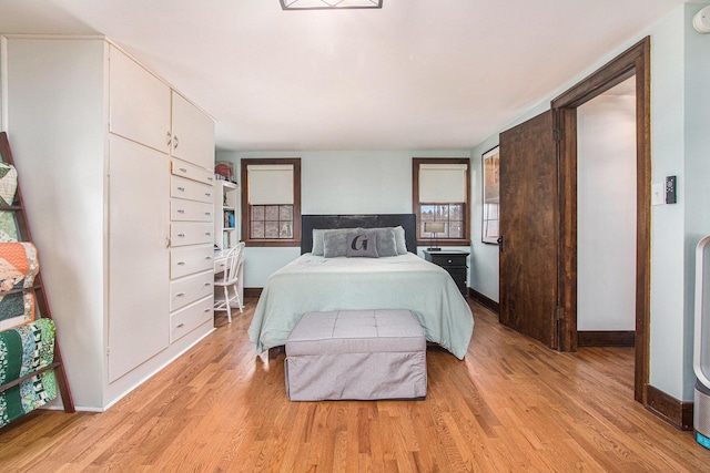 bedroom with light wood-type flooring and baseboards