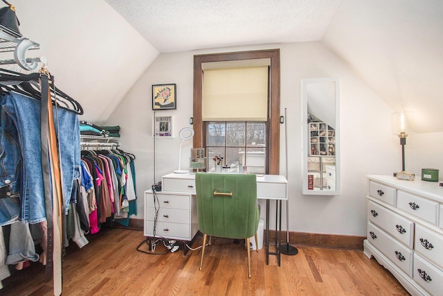 walk in closet featuring vaulted ceiling and light wood-style flooring