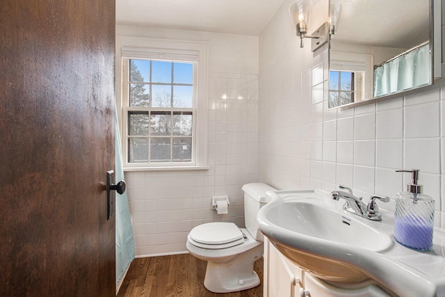 bathroom with plenty of natural light, tile walls, and wood finished floors