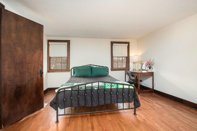 bedroom featuring wood finished floors and baseboards