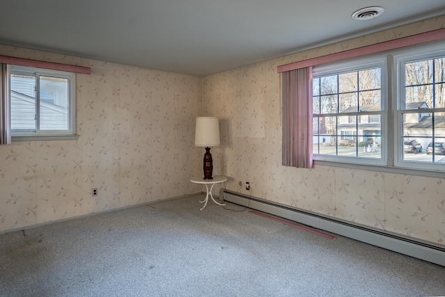 carpeted empty room featuring visible vents, plenty of natural light, wallpapered walls, and a baseboard radiator