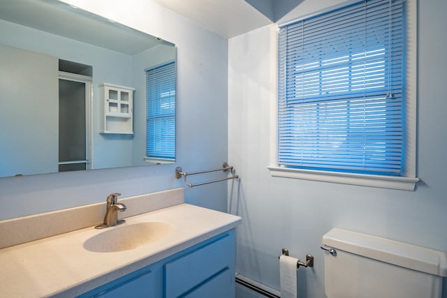 bathroom with vanity, toilet, a baseboard heating unit, and a shower with shower door