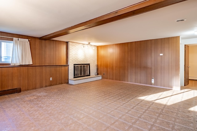 unfurnished living room featuring tile patterned floors, beam ceiling, a brick fireplace, and wood walls