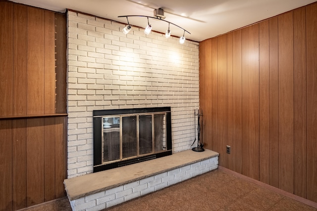 interior details featuring tile patterned floors, wooden walls, rail lighting, and a fireplace