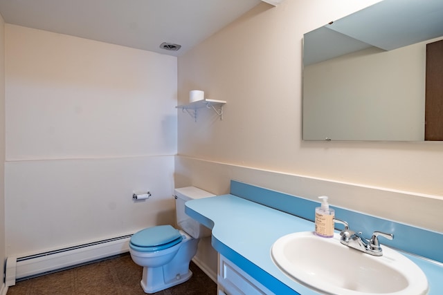 bathroom with a baseboard heating unit, toilet, vanity, and visible vents