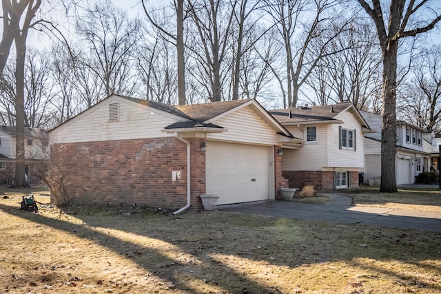 view of side of property with a garage, brick siding, and concrete driveway