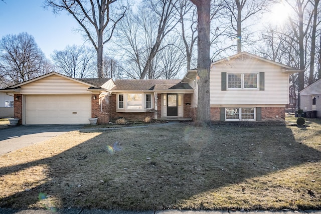 tri-level home with concrete driveway, an attached garage, and brick siding