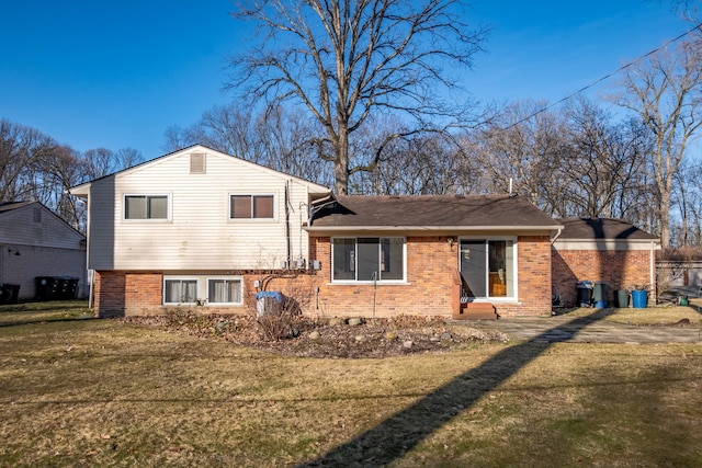 back of house with brick siding and a lawn