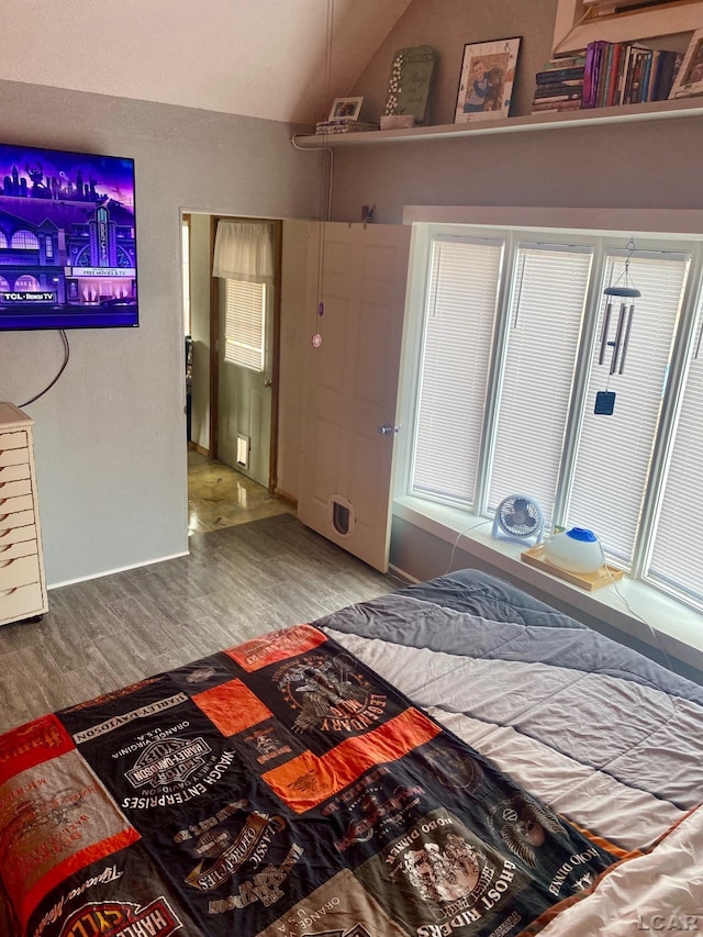 bedroom with vaulted ceiling and wood finished floors