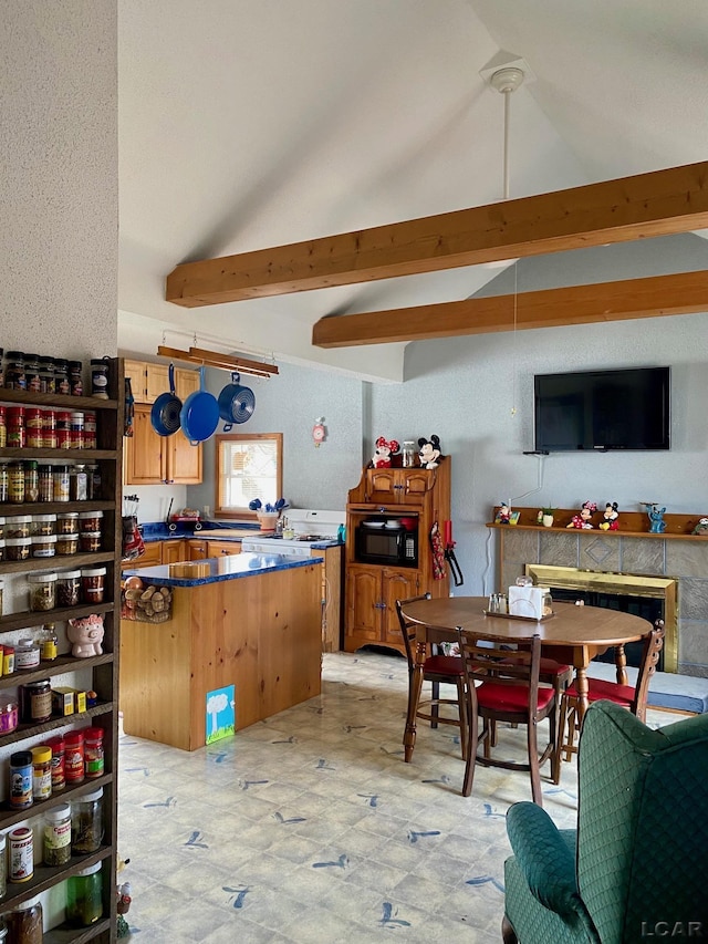 kitchen featuring vaulted ceiling with beams, light floors, dark countertops, a kitchen island, and black microwave