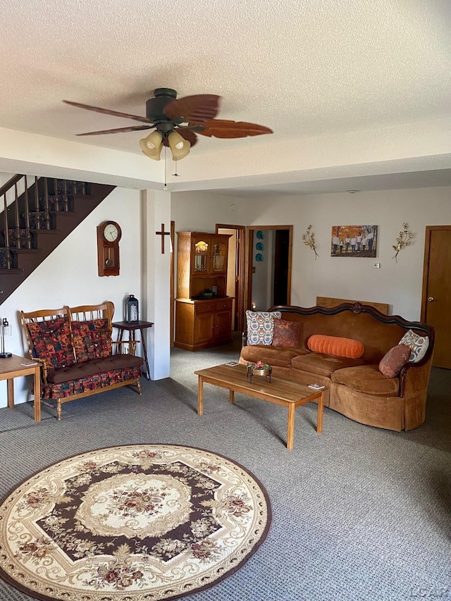 living room with stairs, ceiling fan, a textured ceiling, and carpet flooring