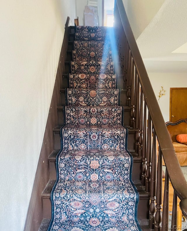 stairs with a textured ceiling