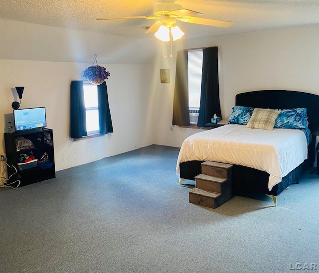 bedroom featuring a textured ceiling, ceiling fan, and carpet floors