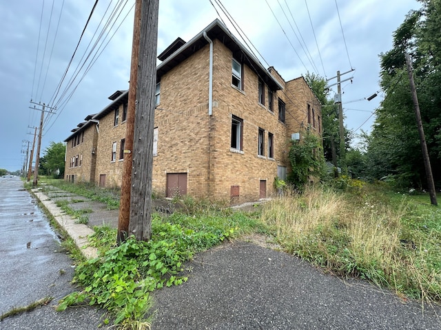 view of side of property featuring crawl space and brick siding