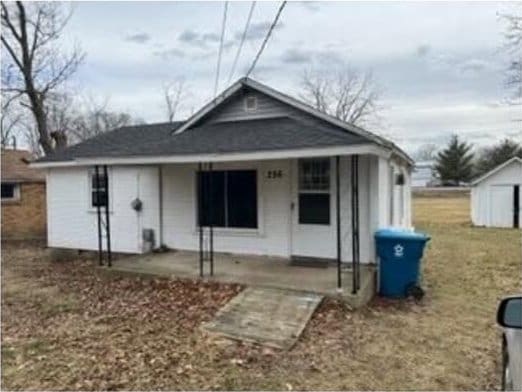 view of front of house featuring an outbuilding, a patio area, and a storage shed