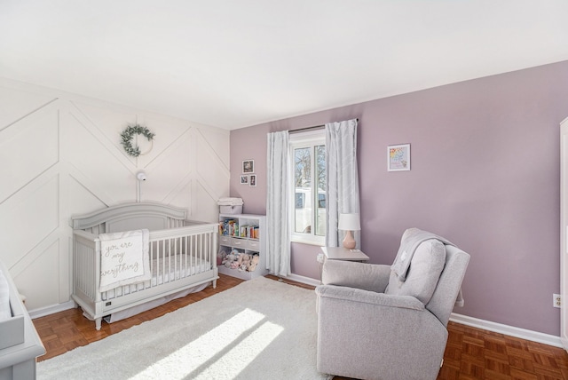 bedroom featuring a nursery area and baseboards