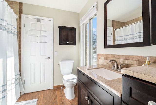 bathroom with toilet, curtained shower, wood finished floors, and vanity