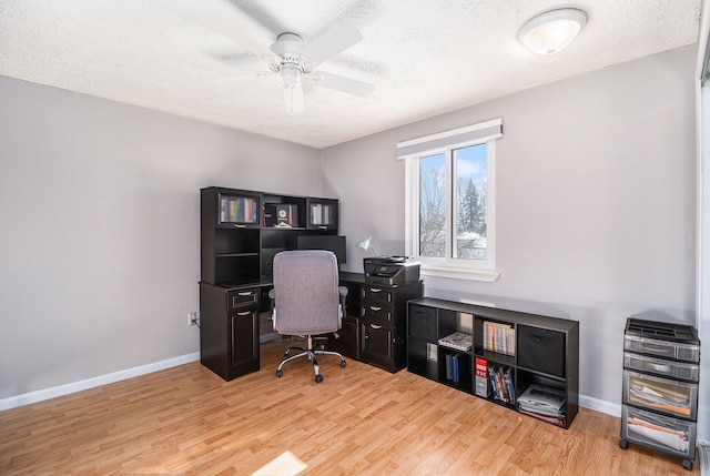 office space featuring a ceiling fan, a textured ceiling, baseboards, and wood finished floors