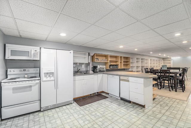 kitchen featuring light floors, open shelves, white cabinetry, a sink, and white appliances