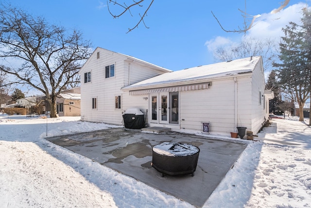 snow covered property with a patio and french doors